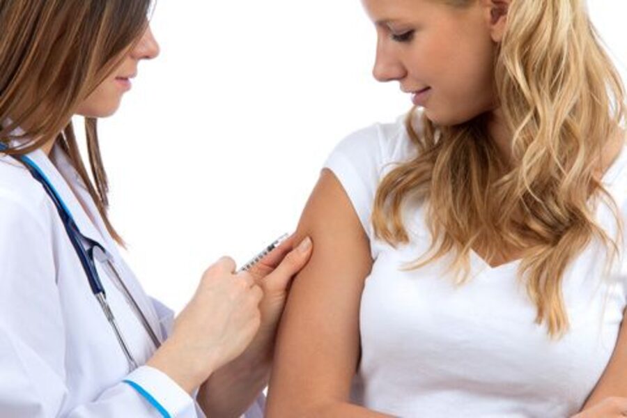 Health professional administering a vaccine to a patient